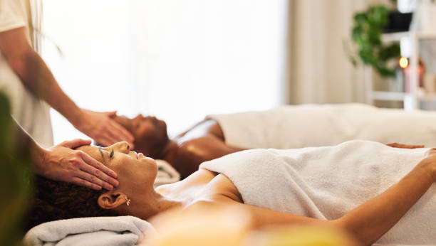 Woman, head massage and couple at beauty spa for body treatment, wellness and facial physical therapy for stress relief, zen and calmness. Skincare salon therapist, woman and healing luxury vacation