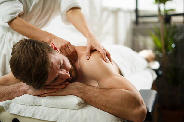 Young man relaxing in the spa and receiving back massage.