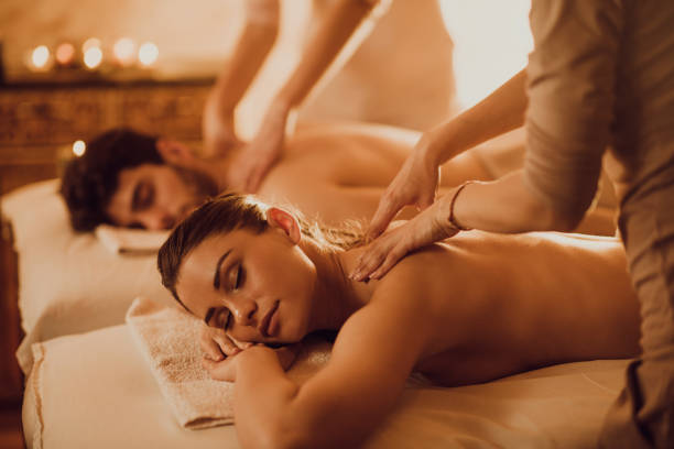 Young couple having back massage during their spa treatment.